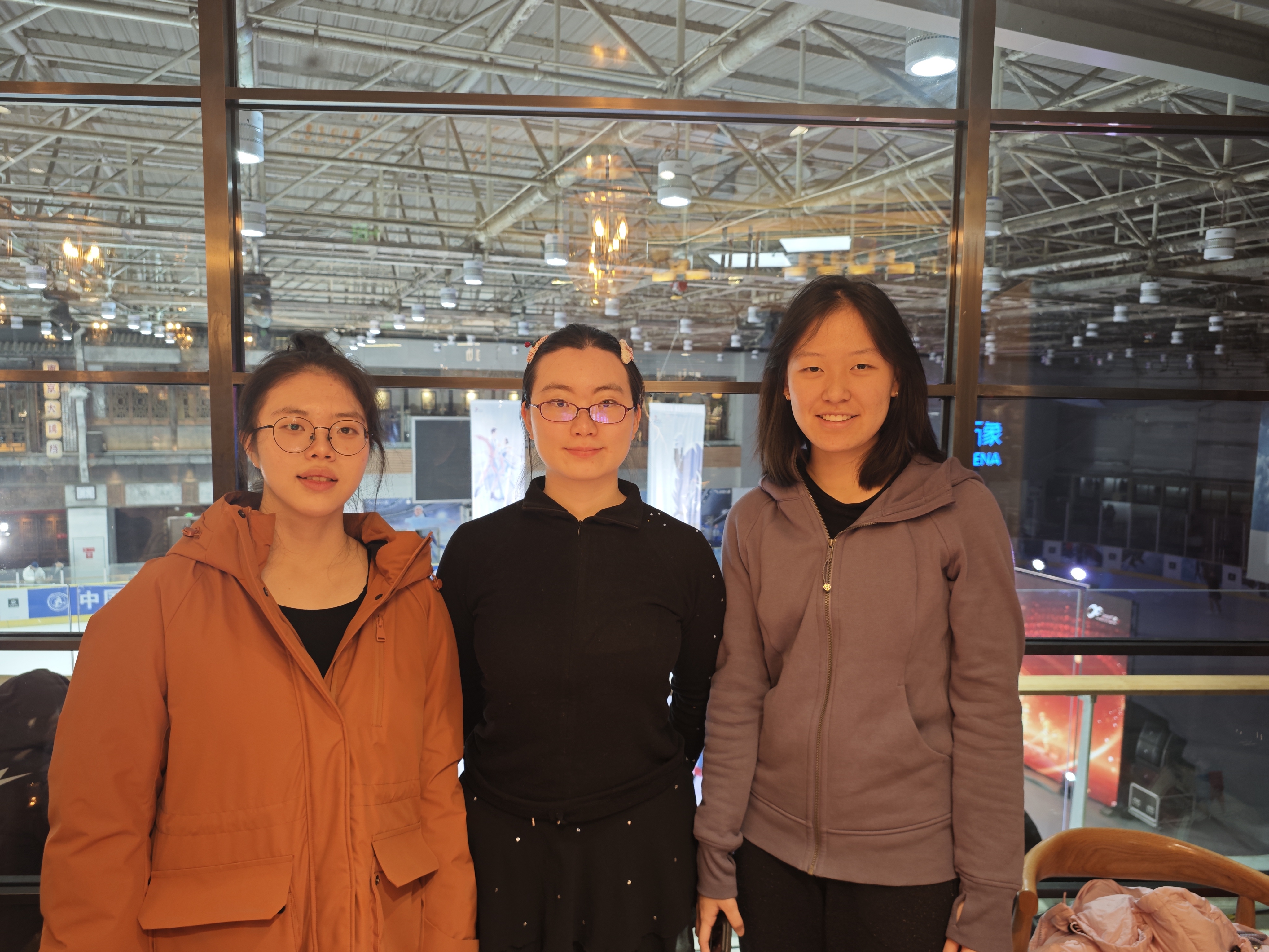 Three women from a skating community at an ice rink