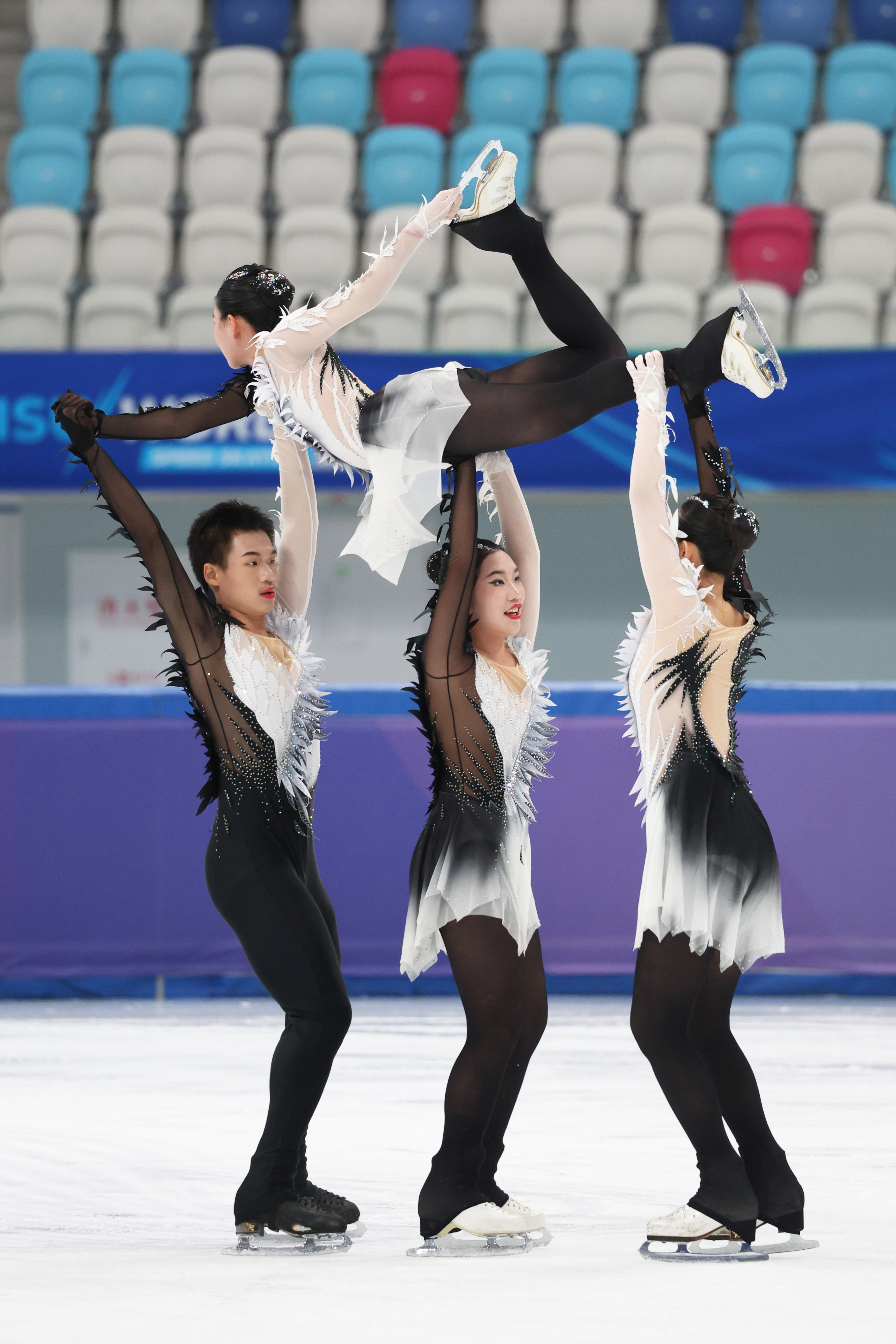 Skating team lifting a teammate during a performance