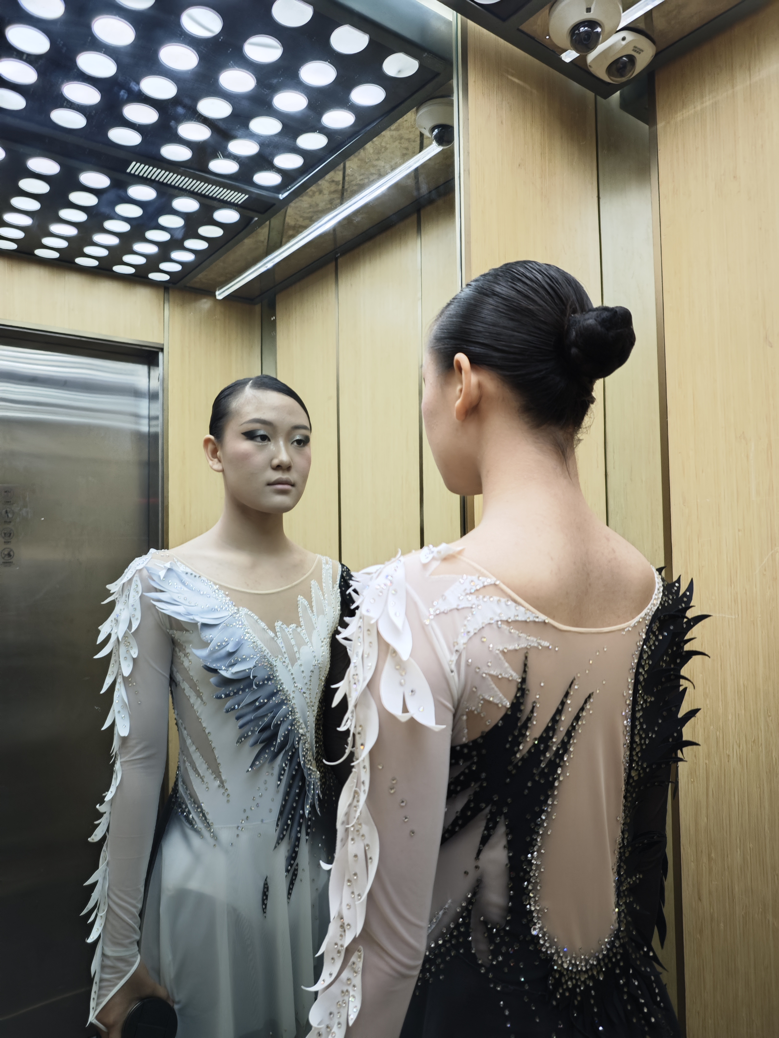 The founder in skating costume looking into a mirror before a performance